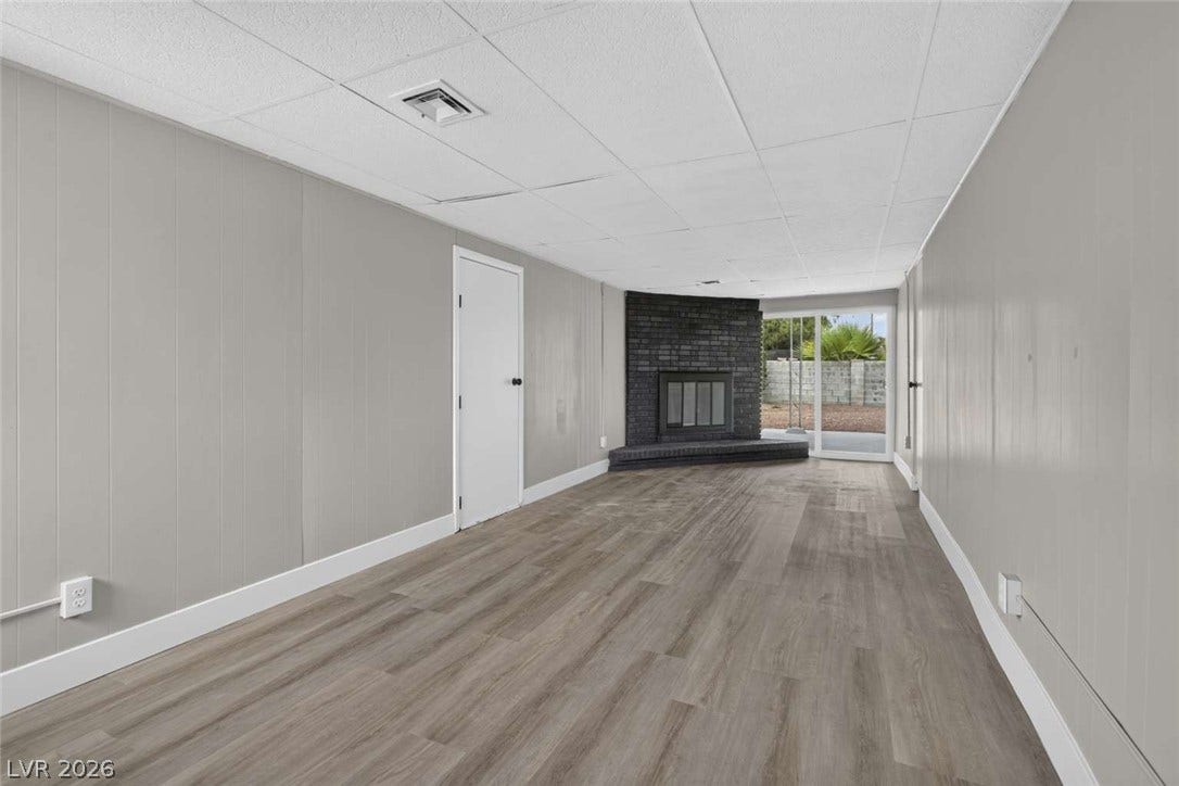 1669 N G Street, Las Vegas, NV 89106 Smooth wood-look flooring anchors this versatile living space featuring a corner brick fireplace.