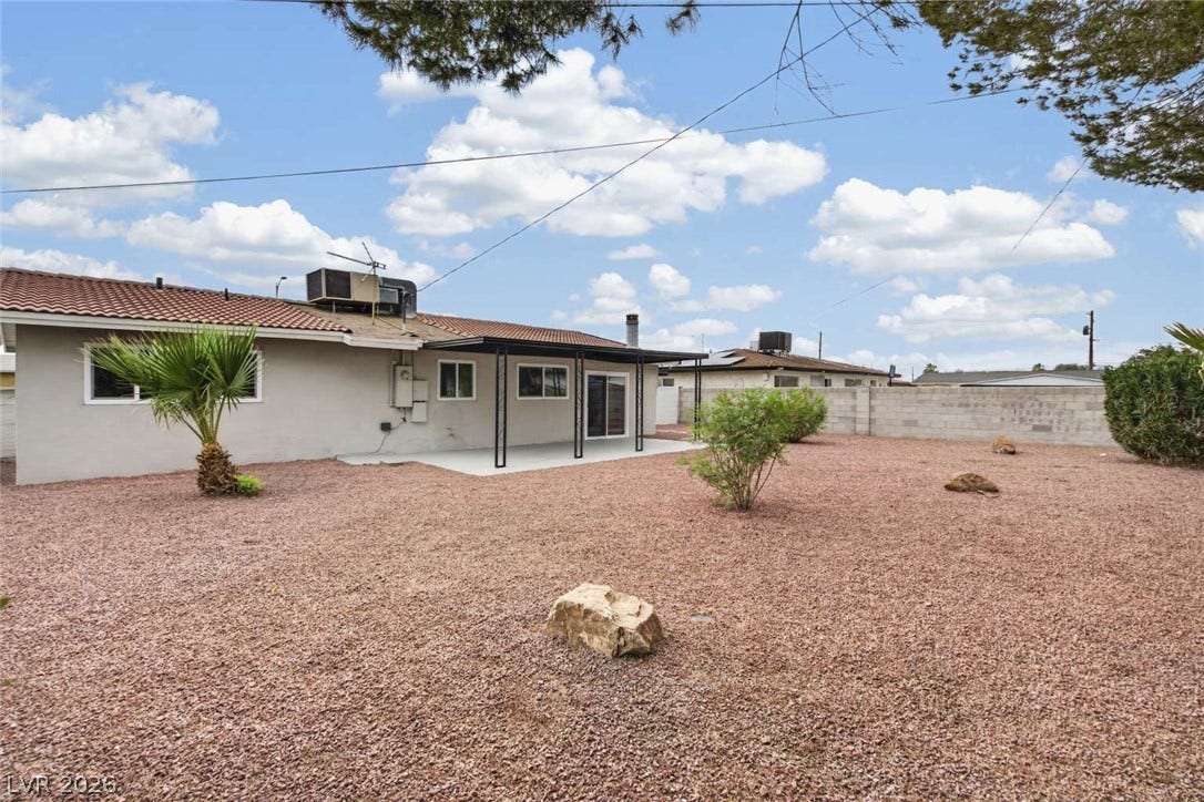 1669 N G Street, Las Vegas, NV 89106 An expansive gravel backyard features a covered concrete patio and a perimeter block wall.