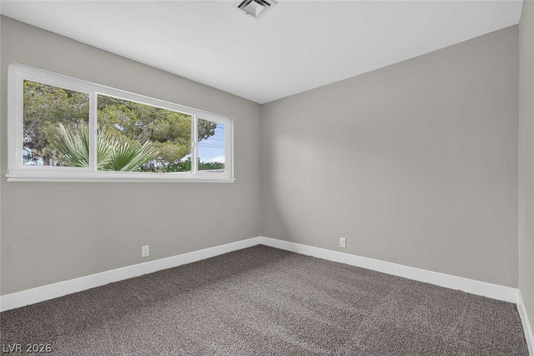 1669 N G Street, Las Vegas, NV 89106 Soft carpeting underfoot and a wide window frame leafy outdoor views in this quiet space.