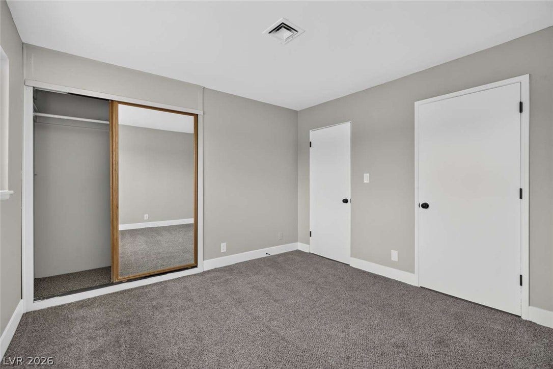 1669 N G Street, Las Vegas, NV 89106 Plush carpeting and mirrored sliding closet doors define this comfortable bedroom space.