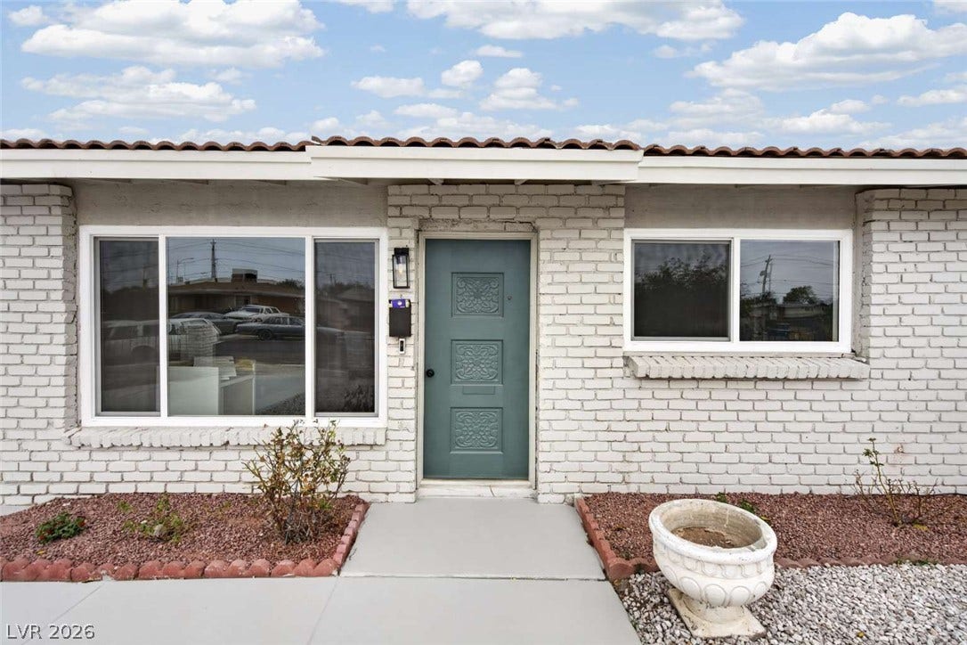 1669 N G Street, Las Vegas, NV 89106 A welcoming front entry features painted brick siding beneath a classic tile roofline.