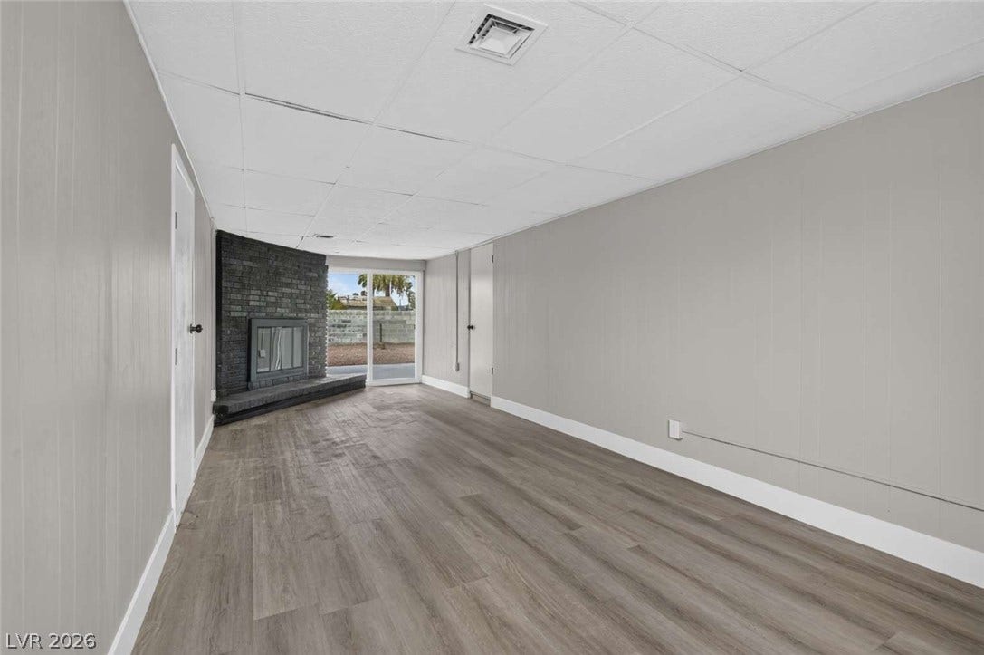 1669 N G Street, Las Vegas, NV 89106 A spacious lower level features durable wood-look flooring and a classic brick fireplace.