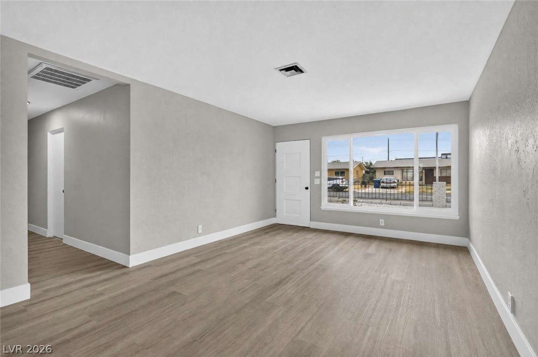 1669 N G Street, Las Vegas, NV 89106 Smooth wood-look flooring and textured walls anchor a welcoming interior space.