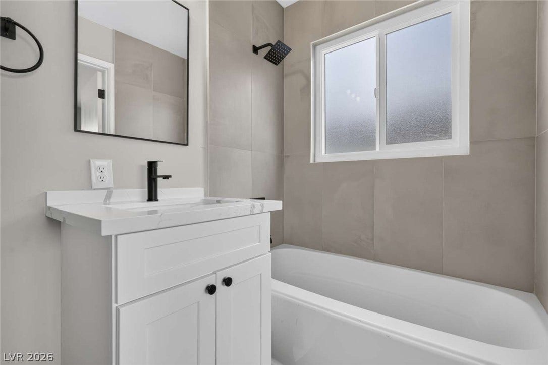 1669 N G Street, Las Vegas, NV 89106 Modern stone tile walls surround the built-in soaking tub in this sleek bathroom.
