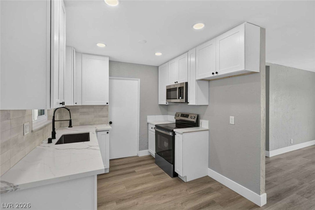 1669 N G Street, Las Vegas, NV 89106 An updated kitchen features stone counters and recessed lighting alongside modern cabinetry.