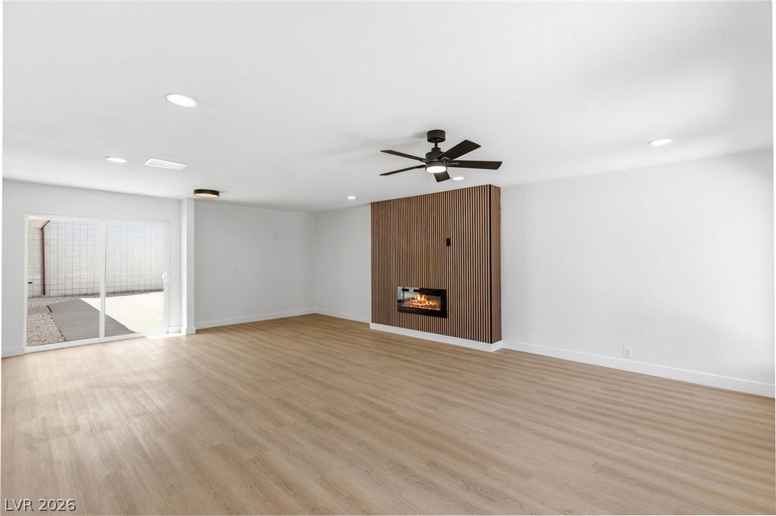3471 One Nation Avenue, Las Vegas, NV 89121 A modern fireplace is the focal point of this spacious, well-lit living area with hardwood floors.