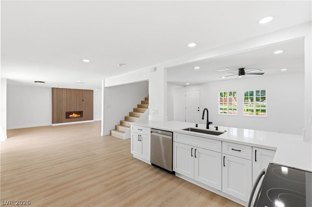 3471 One Nation Avenue, Las Vegas, NV 89121 Bright, open-concept kitchen features sleek counters, modern appliances, and a seamless flow into living areas with a contemporary fireplace.