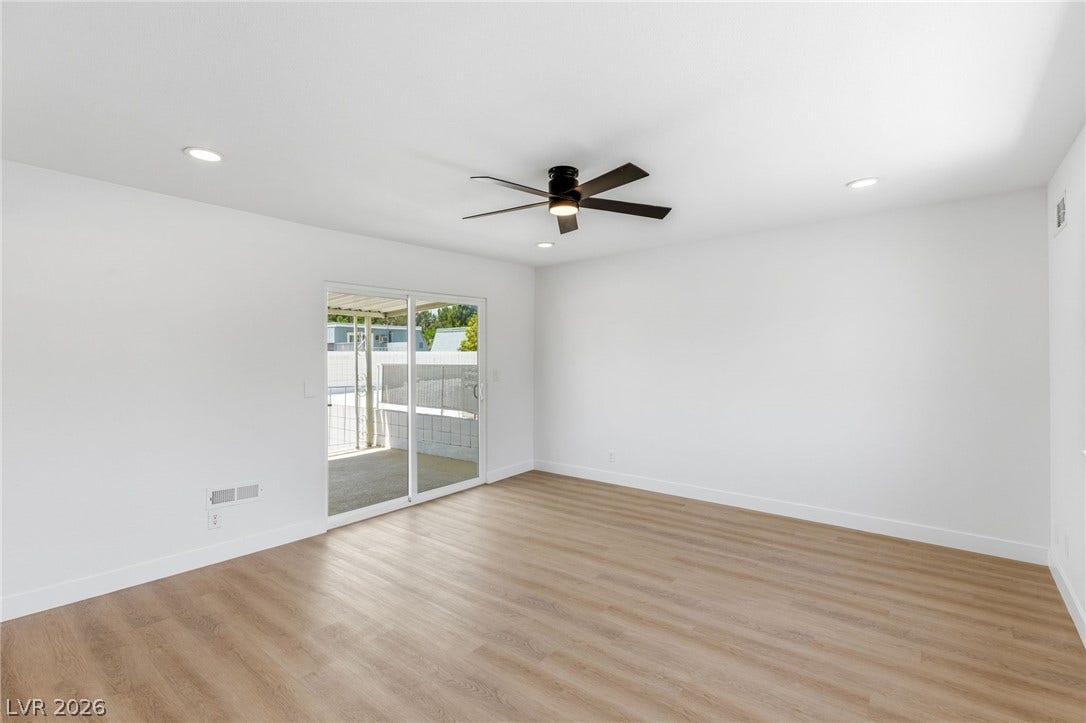 3471 One Nation Avenue, Las Vegas, NV 89121 A spacious room features a sleek ceiling fan and light wood-tone flooring, perfect for versatile living.