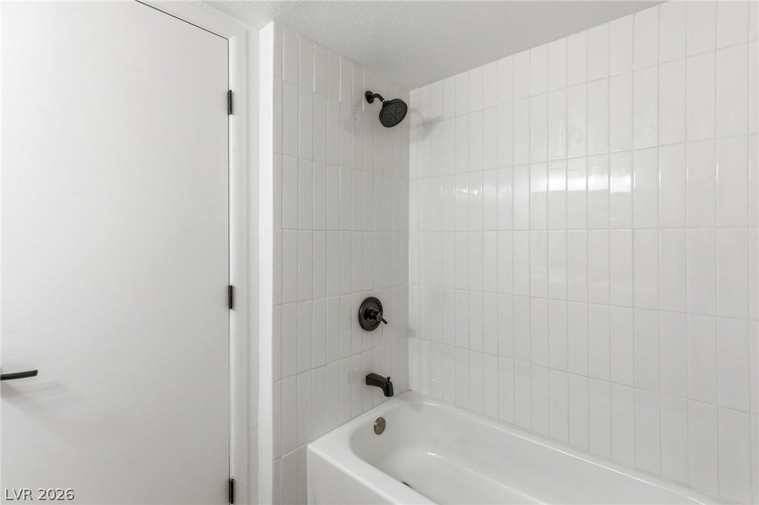 3471 One Nation Avenue, Las Vegas, NV 89121 A pristine bathroom features clean white subway tile surrounding a deep soaking tub and shower.