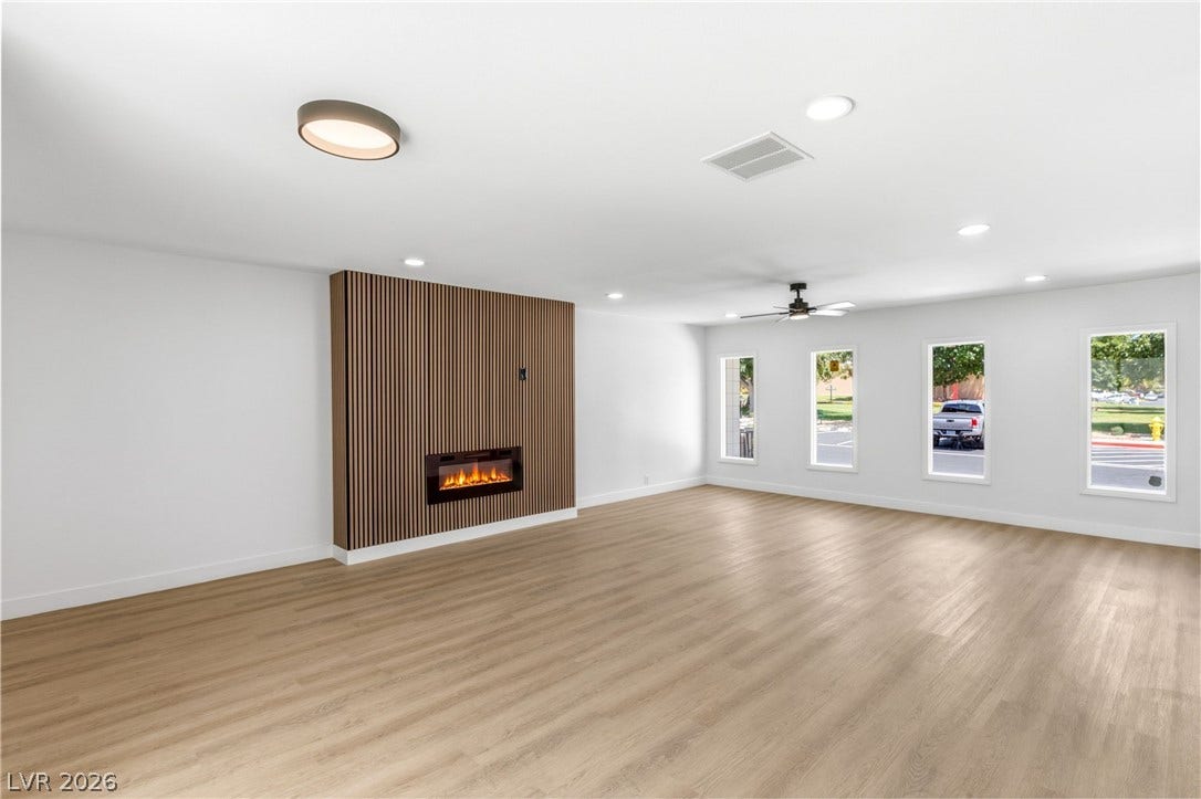 3471 One Nation Avenue, Las Vegas, NV 89121 A spacious room features a sleek electric fireplace with an accent wall and durable laminate flooring.