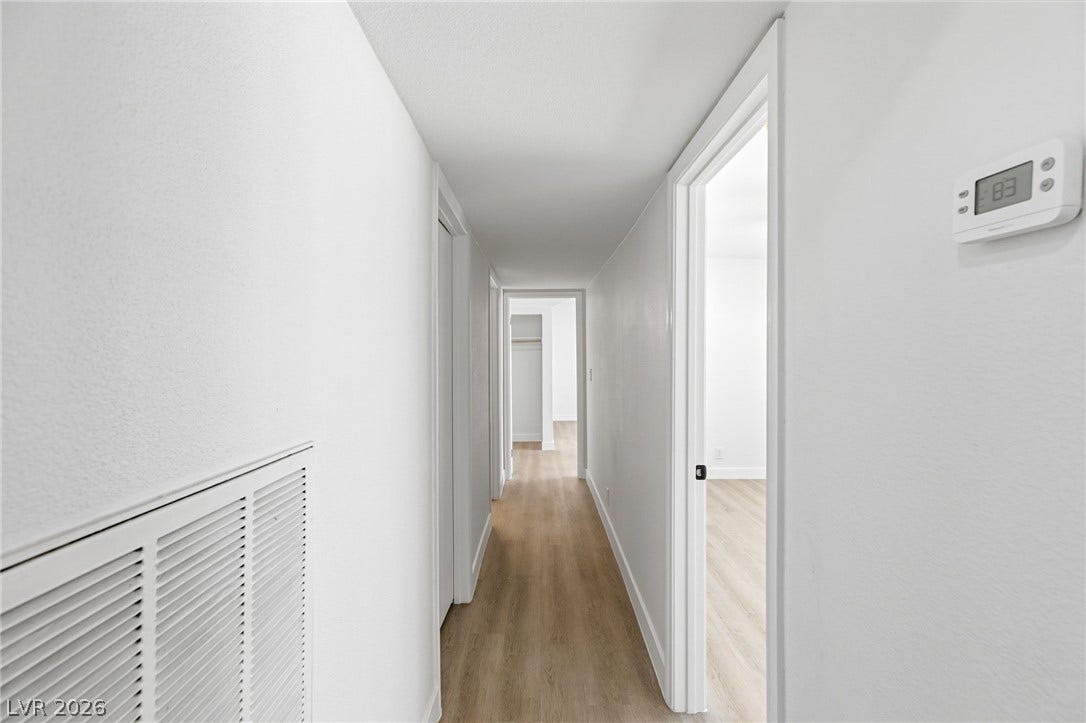 3471 One Nation Avenue, Las Vegas, NV 89121 A well-lit corridor boasts durable wood-look flooring, leading to inviting rooms beyond.