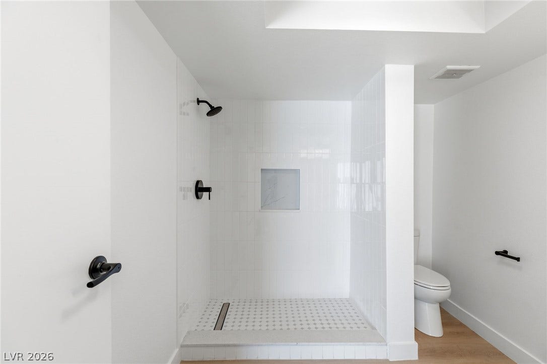 3471 One Nation Avenue, Las Vegas, NV 89121 A modern bathroom showcases a tiled walk-in shower with a sleek linear drain and an integrated wall niche.