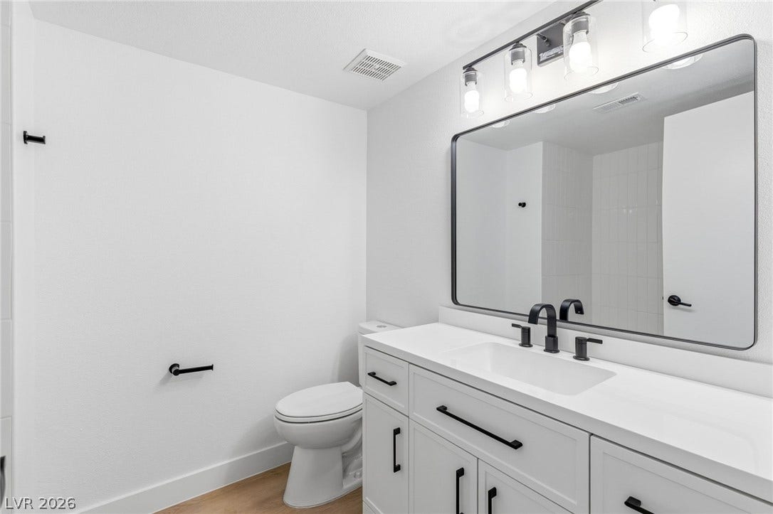 3471 One Nation Avenue, Las Vegas, NV 89121 A well-appointed bathroom features a crisp white vanity and sleek black fixtures.