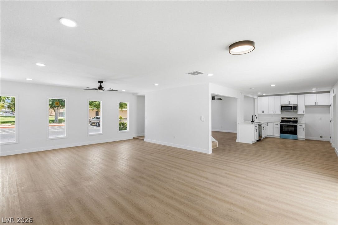 3471 One Nation Avenue, Las Vegas, NV 89121 An airy, open-concept living area seamlessly transitions into a modern kitchen, featuring recessed lighting and durable wood flooring.