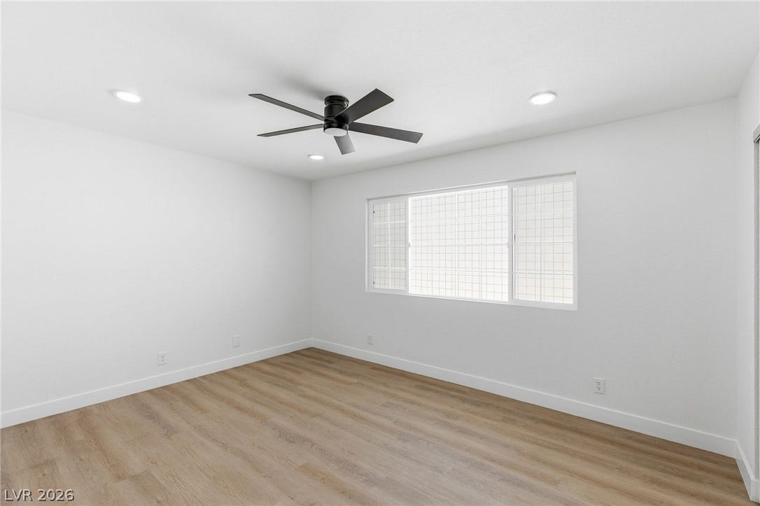 3471 One Nation Avenue, Las Vegas, NV 89121 A well-lit bedroom with modern flooring and a contemporary ceiling fan, ready for personal touches.