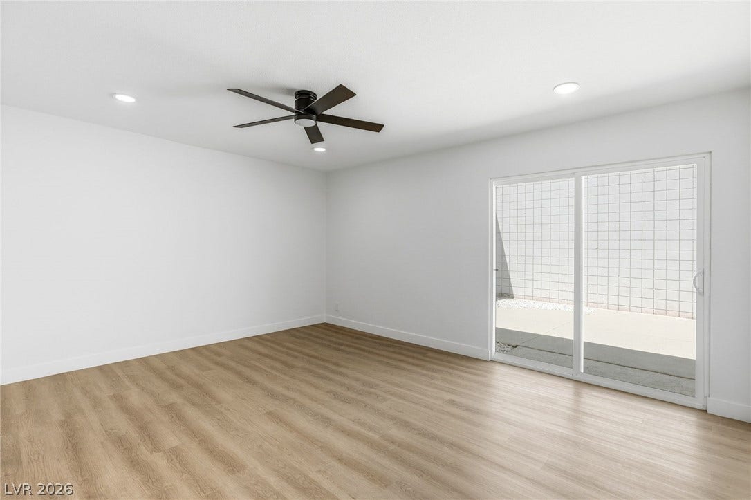 3471 One Nation Avenue, Las Vegas, NV 89121 A quiet living area features durable vinyl plank flooring and convenient sliding glass doors leading to an outdoor space.