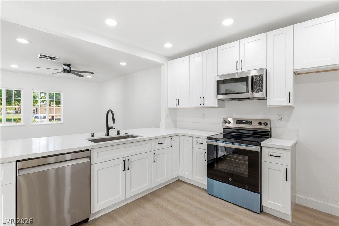 3471 One Nation Avenue, Las Vegas, NV 89121 A pristine culinary space awaits, boasting white cabinetry and integrated stainless steel appliances for seamless meal preparation.