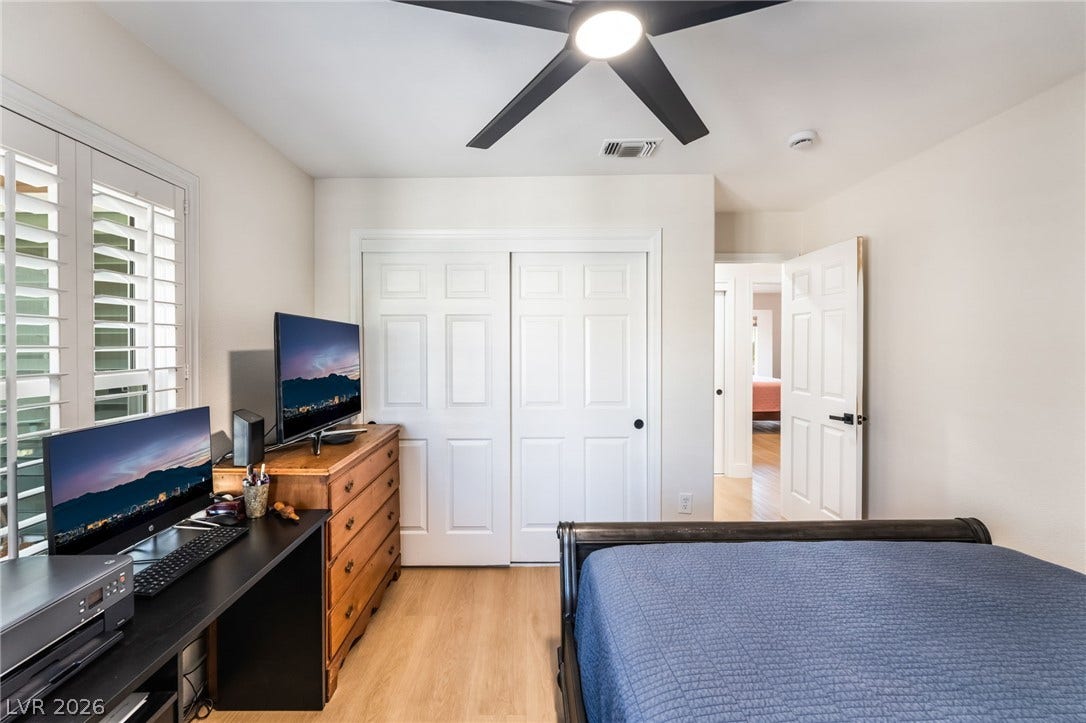 Gleaming hardwood floors and classic plantation shutters enhance this versatile secondary bedroom space.