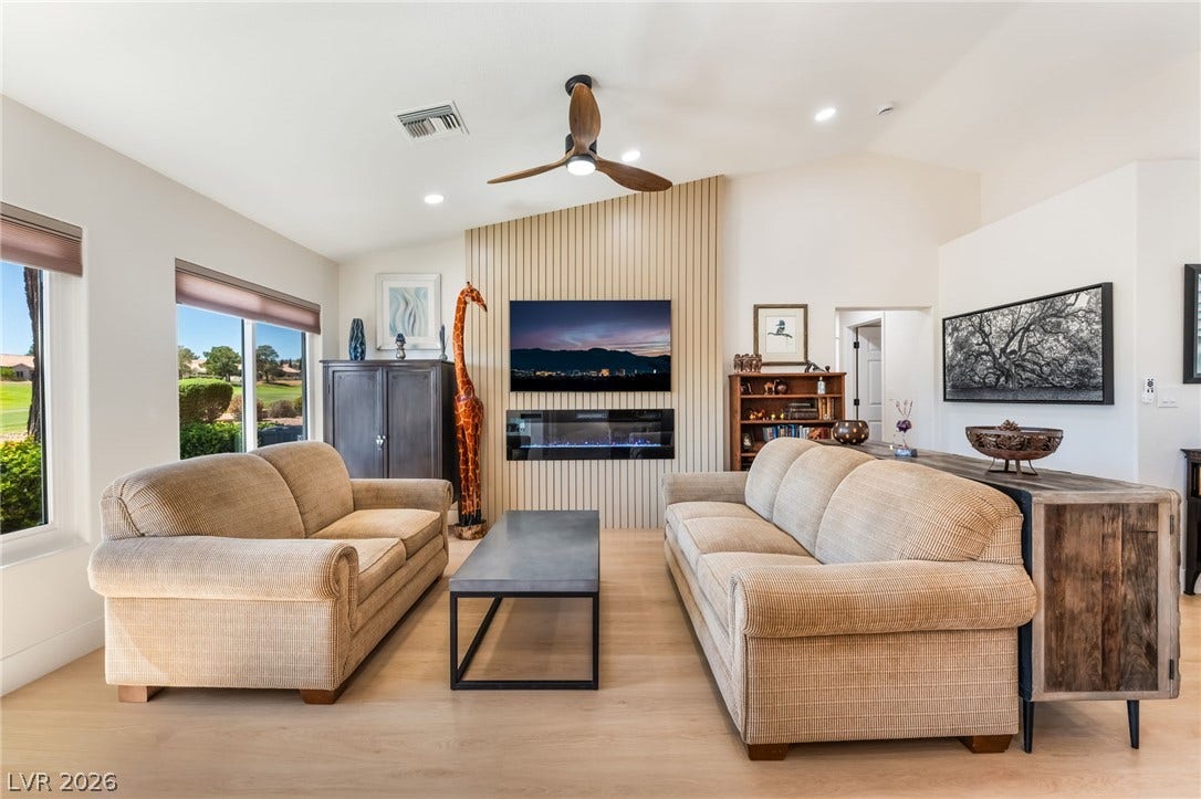 High vaulted ceilings and wood-style flooring elevate this modern living space.