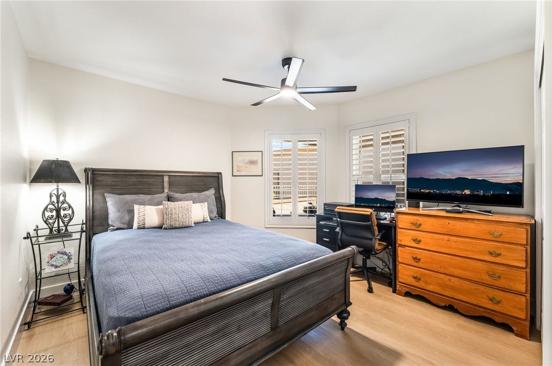 Smooth wood floors and custom plantation shutters enhance this versatile bedroom space.