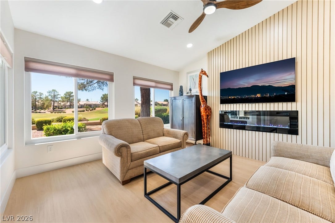 Large picture windows frame golf course views in this light-filled modern living area.