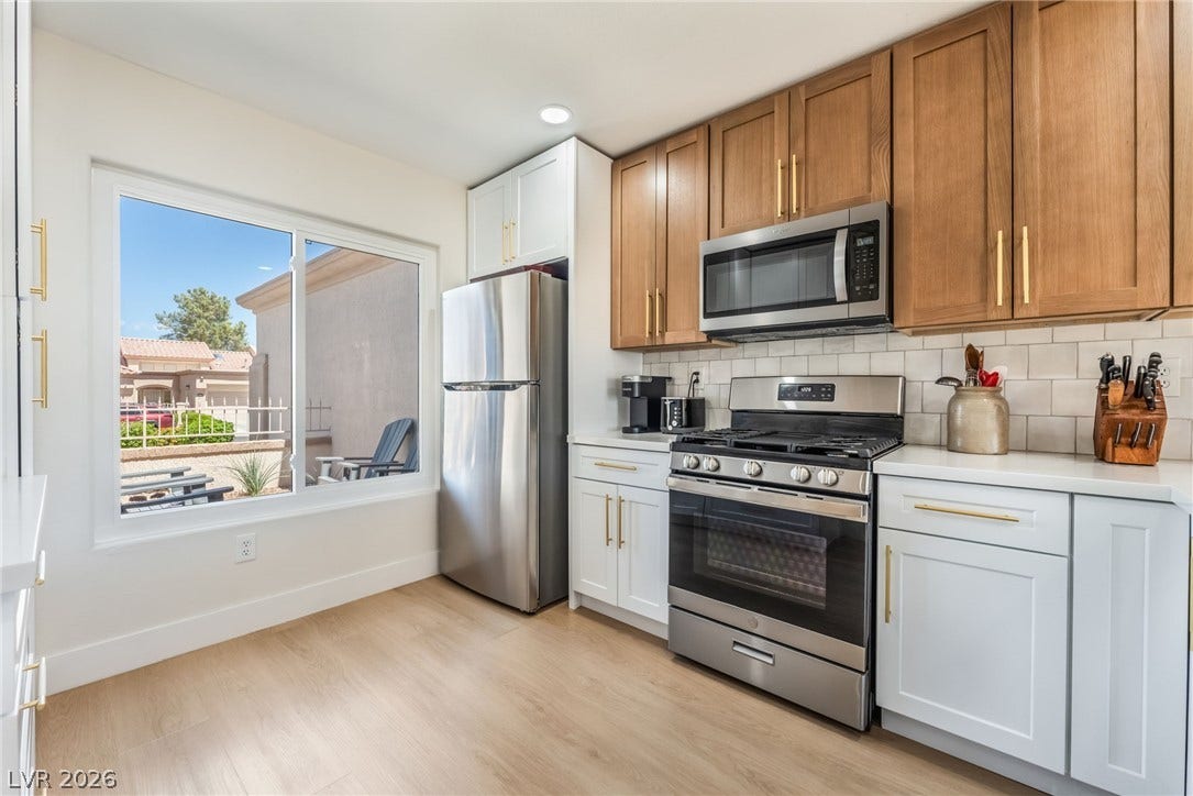 Warm wood and crisp white cabinetry complement durable solid-surface countertops in this bright kitchen.