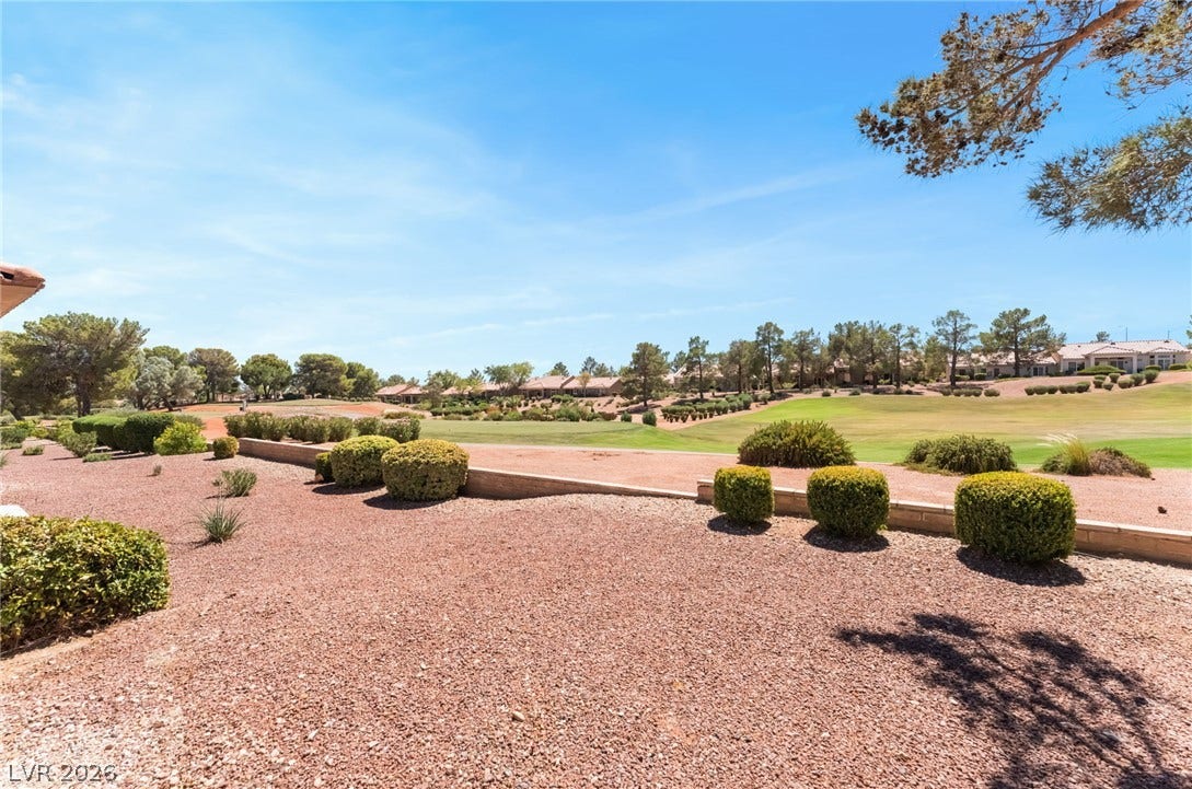 Manicured desert landscaping frames sweeping views of the rolling green golf course.