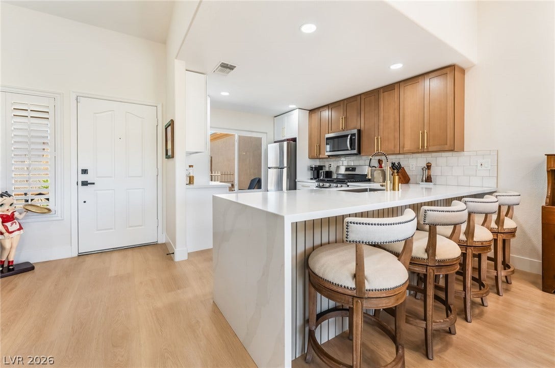 Smooth wood floors and stone counters elevate this modern kitchen designed for entertaining.