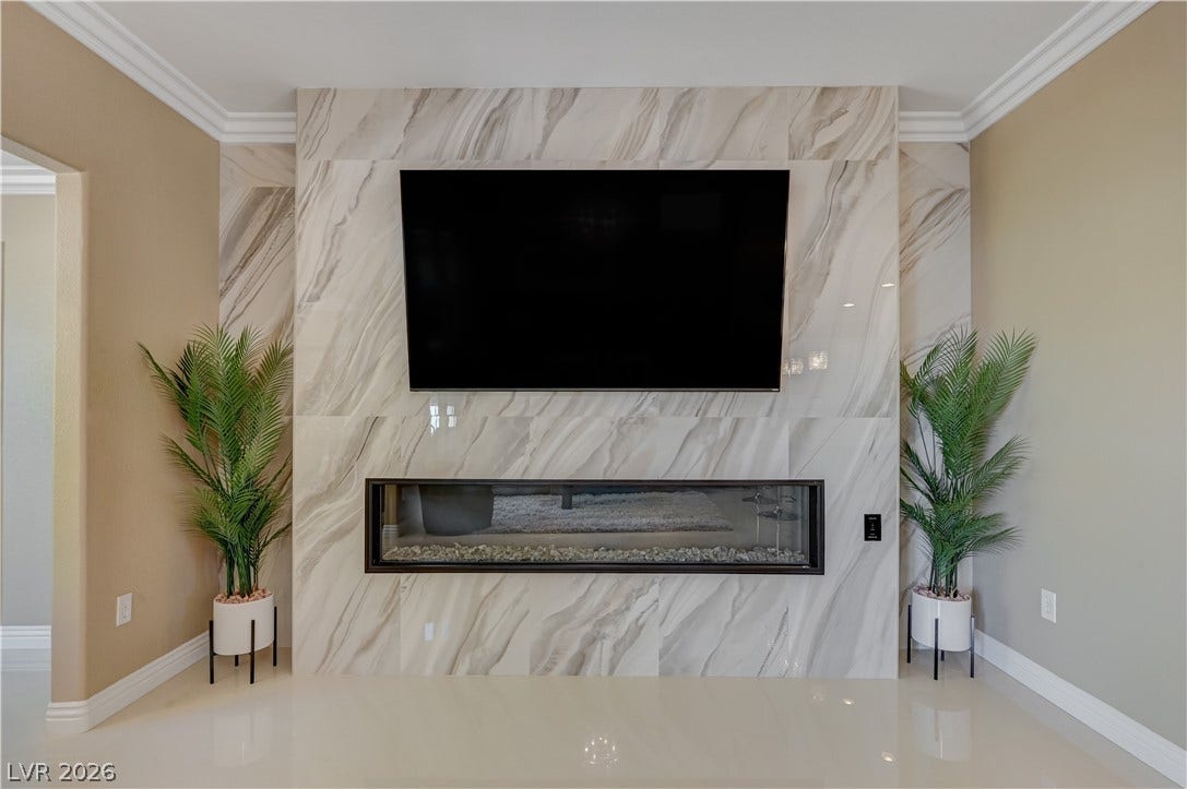 A sleek modern fireplace with a marble-patterned surround anchors this elegant living space.