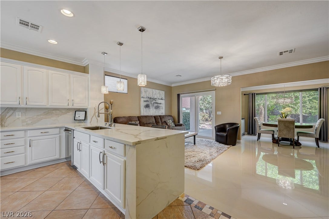 An open floorplan seamlessly connects the stylish kitchen to the adjoining dining and living spaces.
