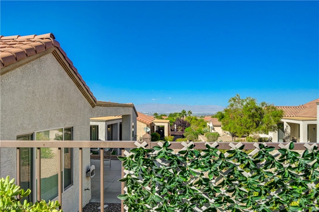 Distant mountains frame the horizon beyond this tiled-roof suburban residence.