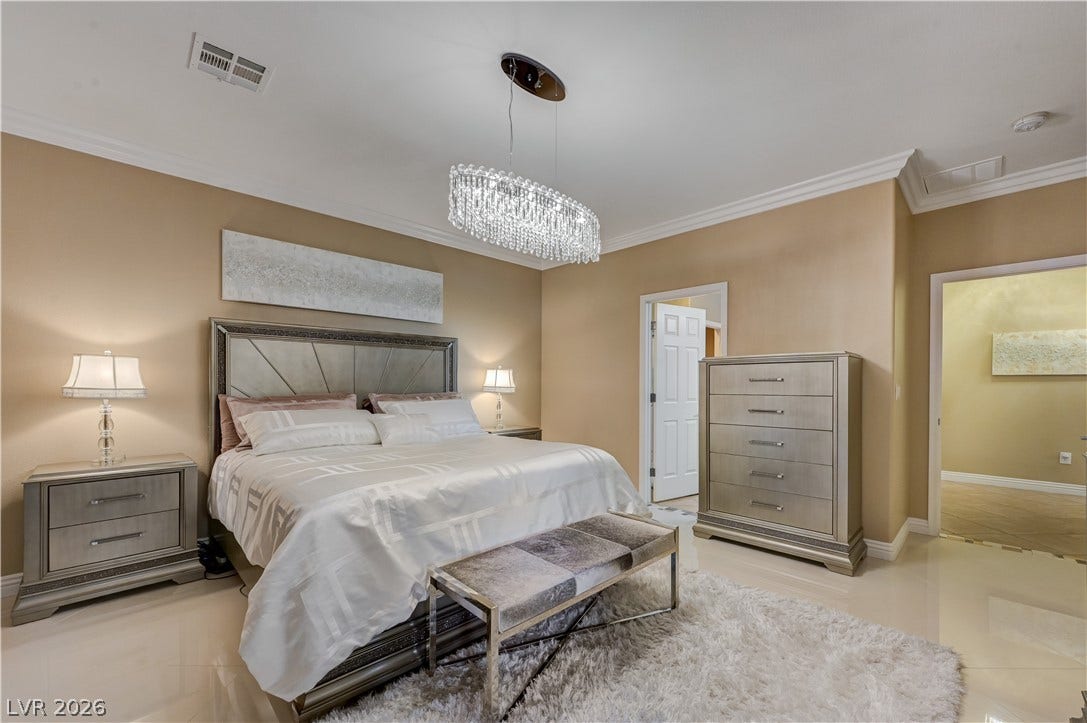 Polished tile flooring and elegant crown molding define this refined bedroom suite.