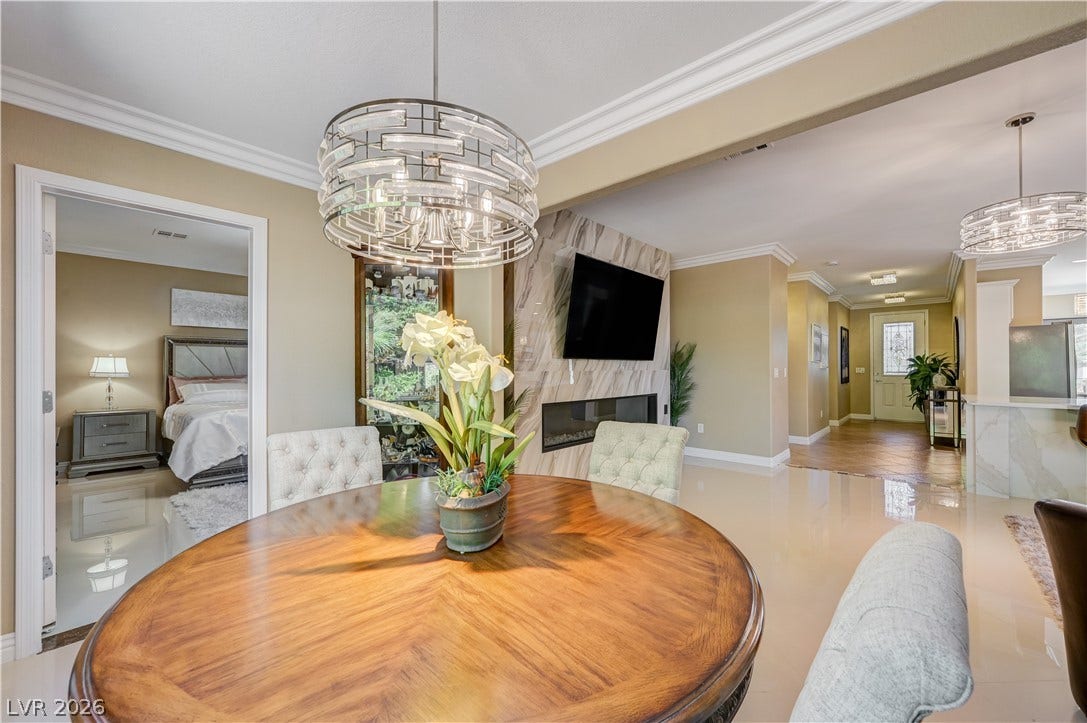 Polished tile flooring and elegant crown molding define this open concept dining space.