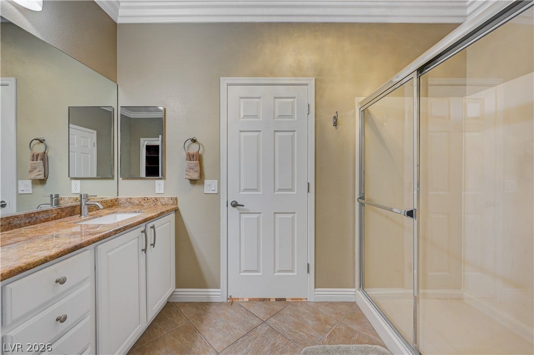 Rich stone countertops and tile flooring elevate this elegant bathroom space.