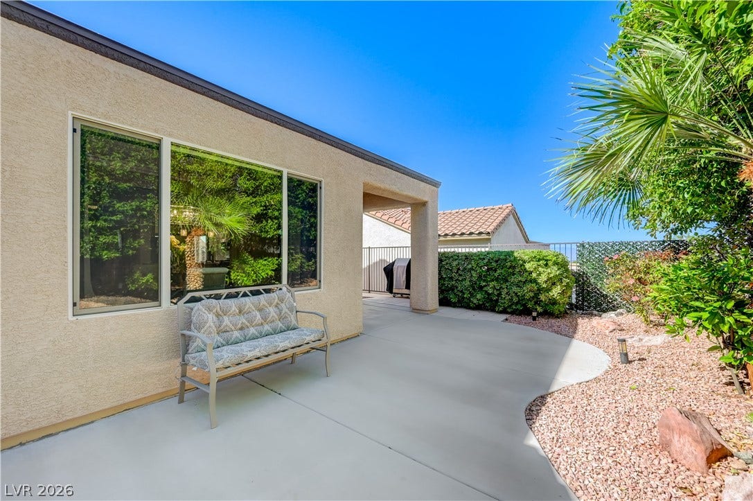 Smooth concrete patio lines a stucco exterior under clear desert skies.