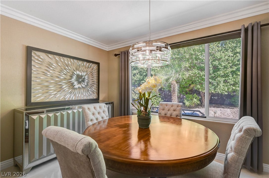Elegant crown molding and a large picture window frame the dining area perfectly.