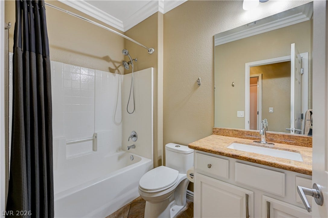 Elegant crown molding complements stone counters in this classic bathroom space.