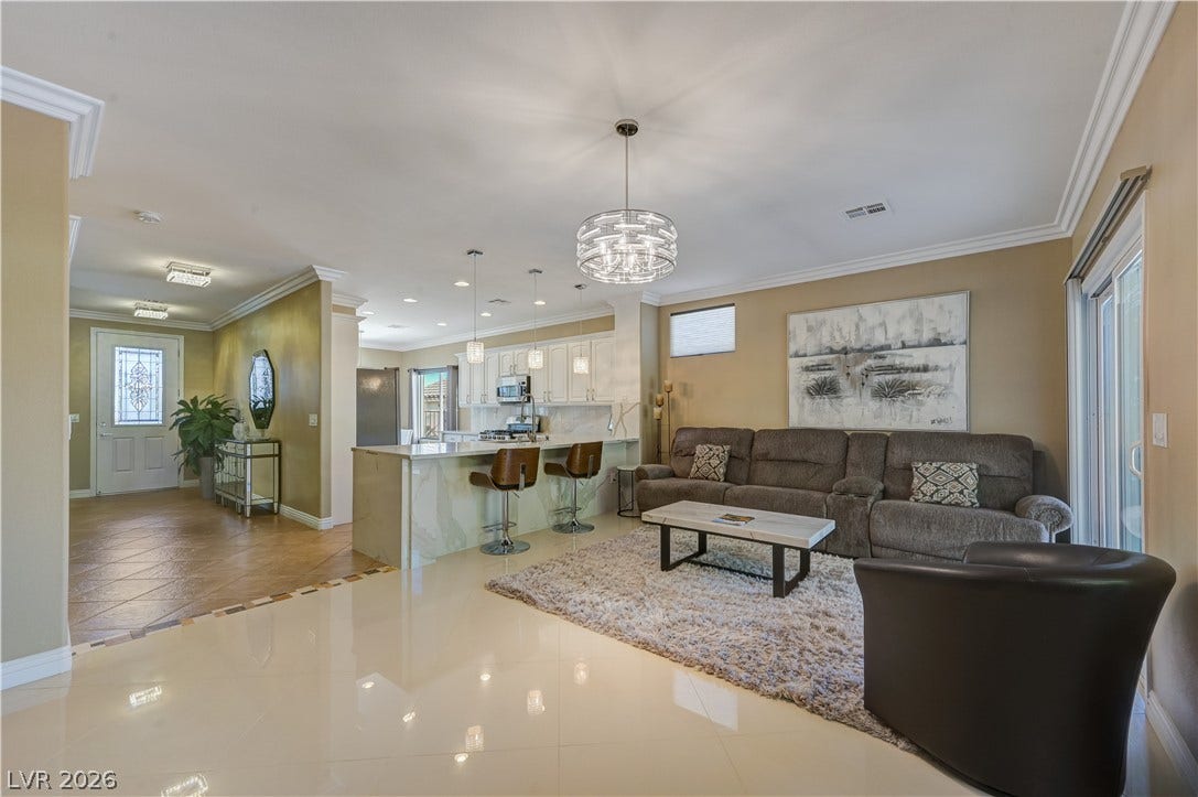 Polished tile flooring and elegant crown molding define this open-concept main level.