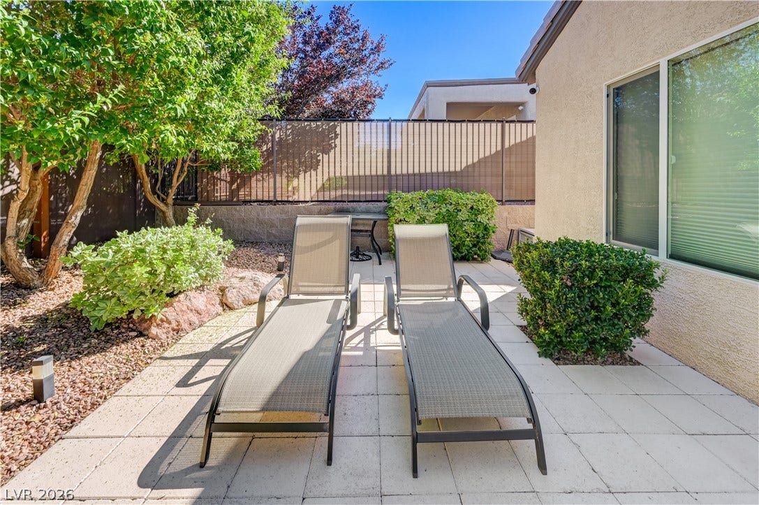 A private paved courtyard provides a serene outdoor retreat bordered by mature greenery.