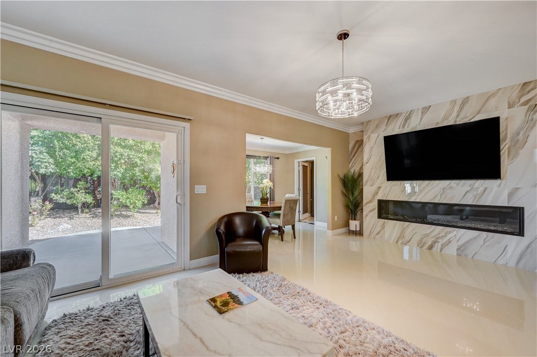 Polished tile flooring and a sleek modern fireplace wall ground this open living space.