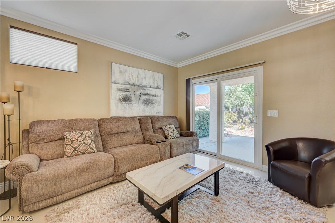 Crown molding and sliding glass doors highlight this comfortable living area.