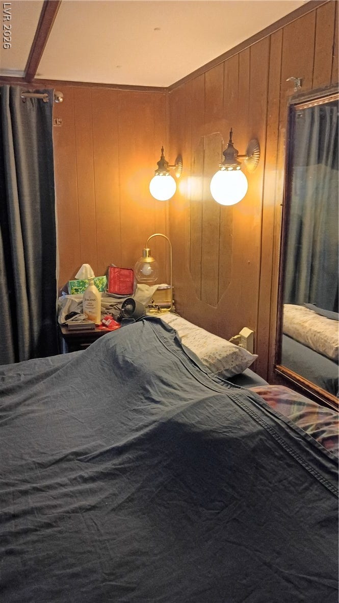 3490 E Savoy Boulevard, Pahrump, NV 89061 Warm wood paneling brings cozy mid-century character to this bedroom space.