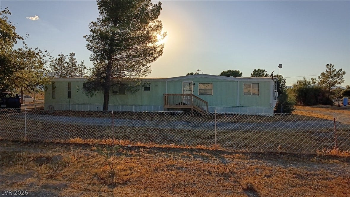 3490 E Savoy Boulevard, Pahrump, NV 89061 A spacious yard surrounds this manufactured home bordered by mature trees and perimeter fencing.