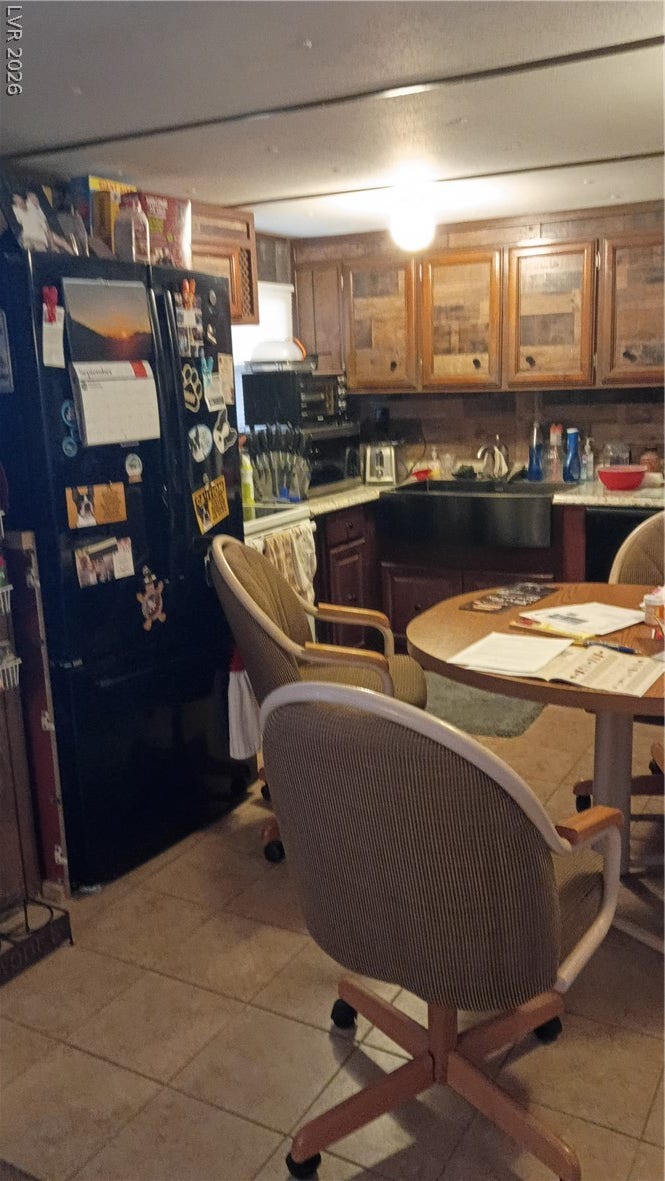 3490 E Savoy Boulevard, Pahrump, NV 89061 Warm wood cabinetry and tile flooring define this functional kitchen and dining space.