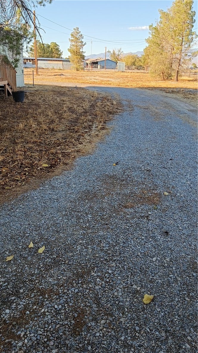 3490 E Savoy Boulevard, Pahrump, NV 89061 A long gravel driveway leads through the open property toward distant mountain views.