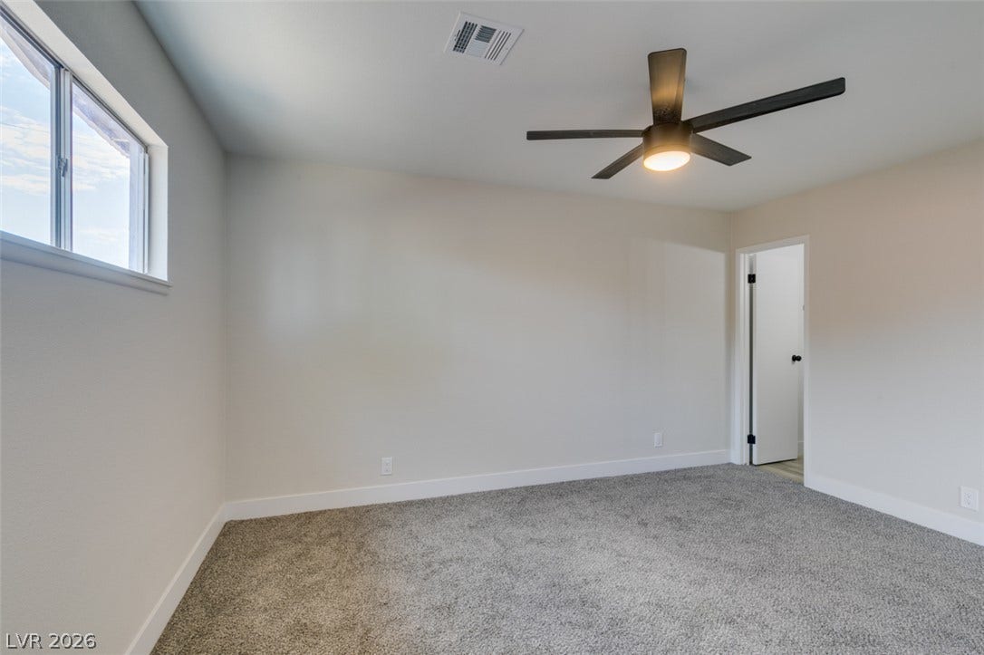 Plush carpeting anchors this inviting space illuminated by a wide window framing sky views.