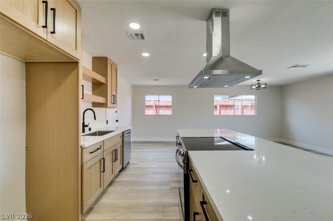 An open kitchen layout showcases sleek quartz countertops and a massive central island.