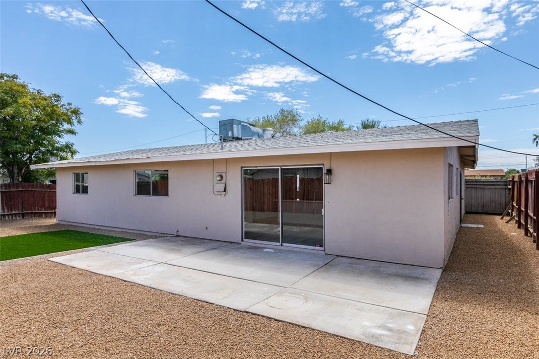 An open concrete patio extends from the back of this single-story stucco home.