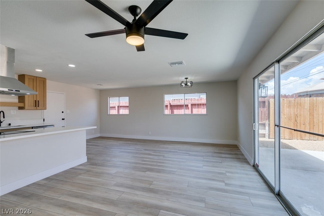 Gleaming wood-look floors anchor this airy living space next to the kitchen.