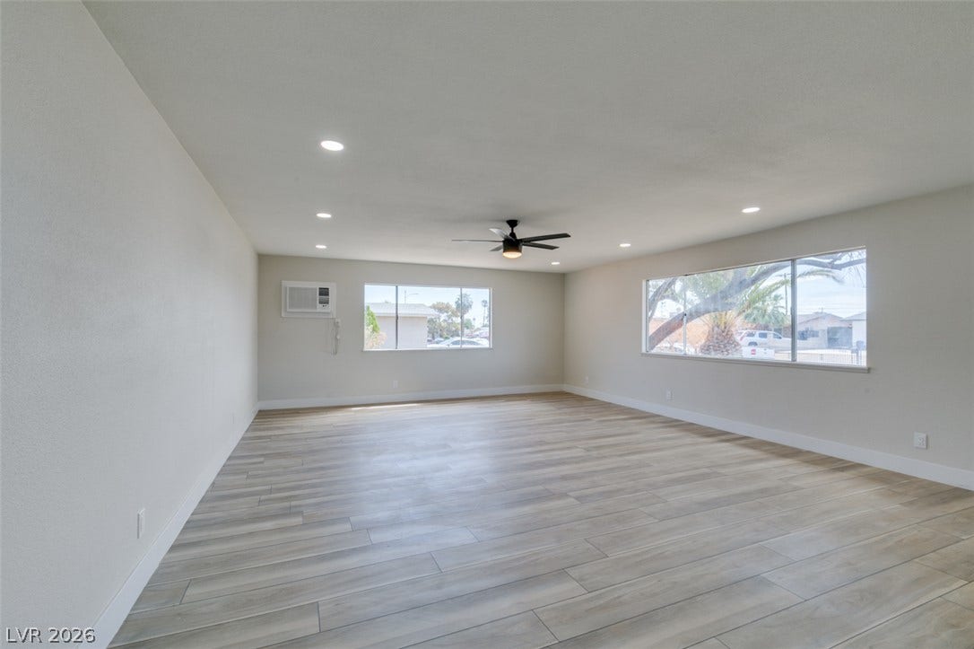 Laminate flooring and recessed lighting define this expansive open living space.